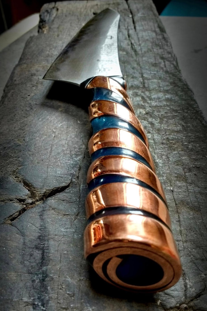 Handmade kitchen knife with copper spiral and blue resin handle. 